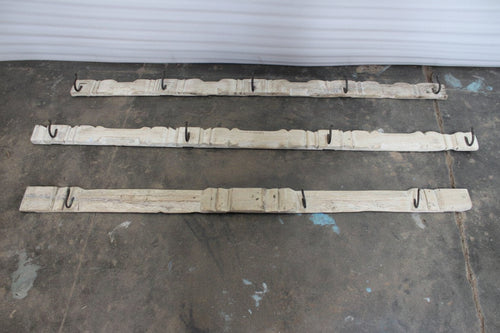 Three wooden carved panels with hooks