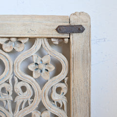 Wooden decorative panel with intricate carvings on a white background