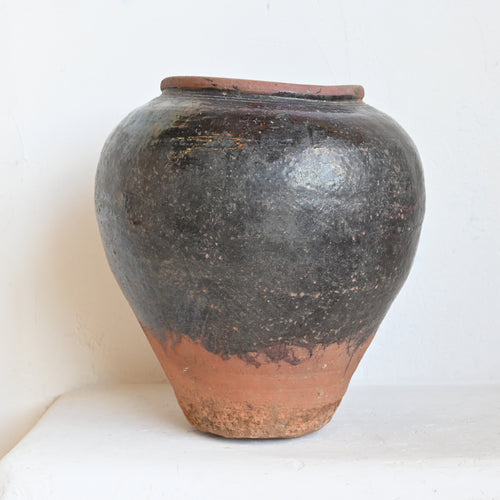 Stoneware vase with a rustic finish on a white background