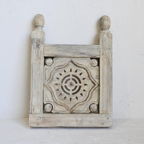 Wooden decorative panel with intricate carvings on a white background