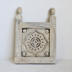 Wooden decorative panel with intricate carvings on a white background