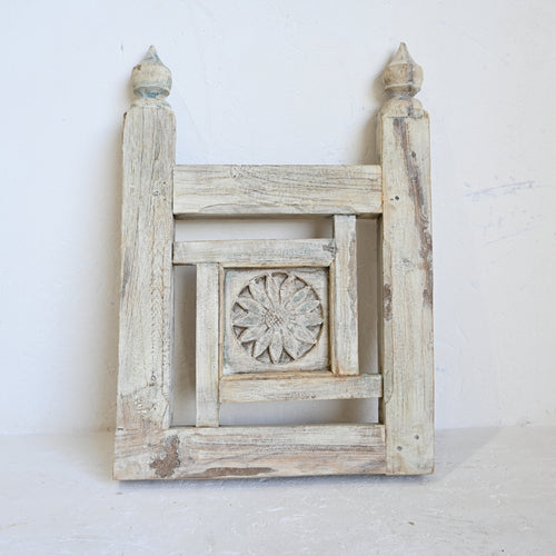 Decorative wooden panel with intricate carvings on a white background