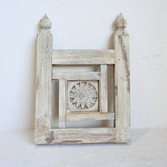 Decorative wooden panel with intricate carvings on a white background