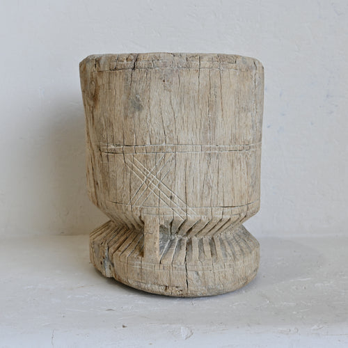 Wooden pot with carved patterns on a white background