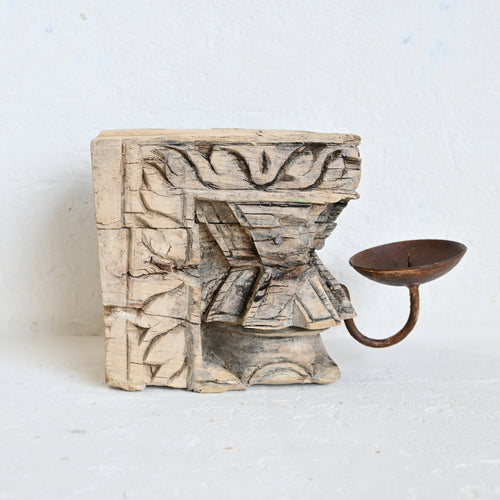 Decorative wooden candle holder with intricate carvings on a white background
