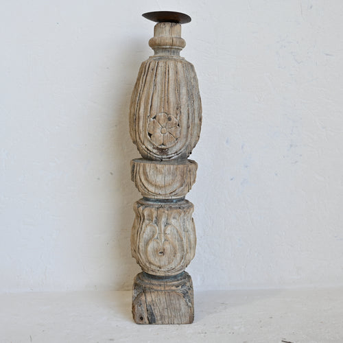 Decorative wooden candle holder with intricate carvings on a white background