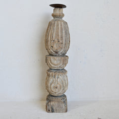 Decorative wooden candle holder with intricate carvings on a white background