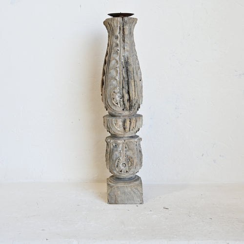 Decorative wooden candle holder with intricate carvings on a white background