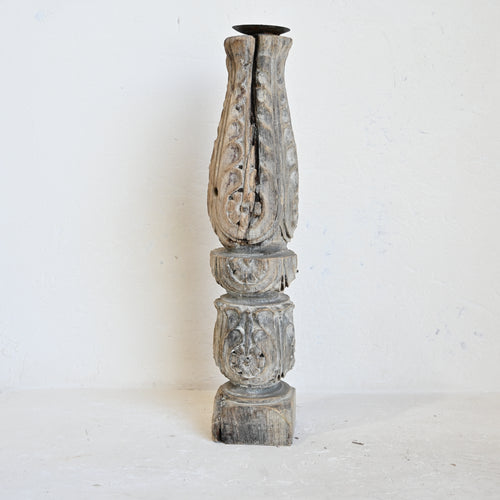 Decorative wooden column with intricate carvings on a white background