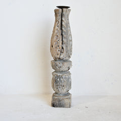 Decorative wooden column with intricate carvings on a white background