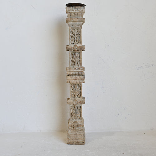 Decorative wooden candle holder with intricate carvings on a white background