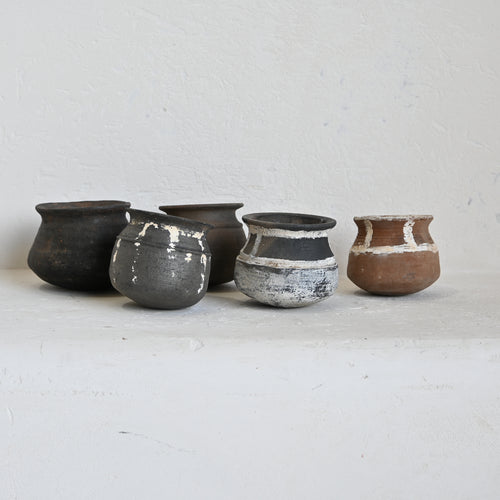 Set of five clay pots on a light gray background