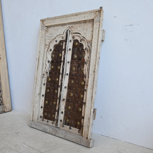 Decorative wooden panel with intricate carvings on a light blue background