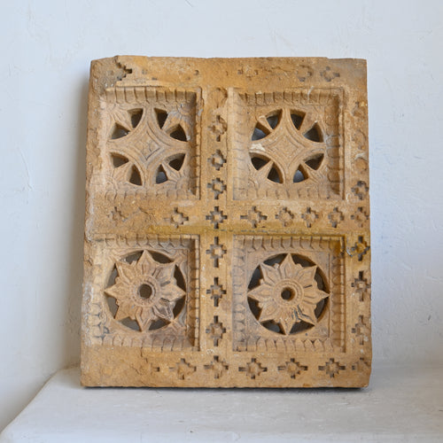 Decorative wooden panel with intricate carvings on a white background