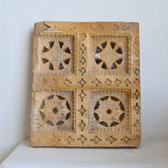 Decorative wooden panel with intricate carvings on a white background