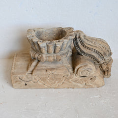 Wooden architectural element with intricate carvings on a light background