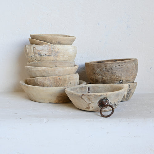stack of vintage wooden bowls in different sizes and distressed finishes