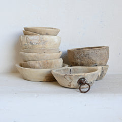 stack of vintage wooden bowls in different sizes and distressed finishes