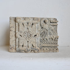 Decorative wooden panel with intricate carvings on a white background
