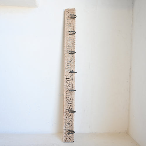 Decorative wooden wall hook with floral pattern on a white background