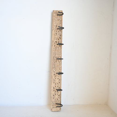 Wooden wall hook with decorative carvings on a white background