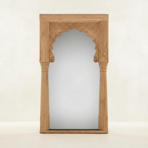 Decorative mirror with an arched wooden frame on a white background
