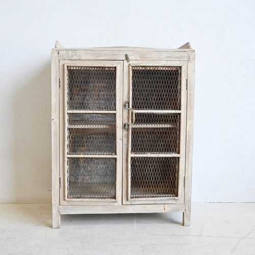 Vintage-style cabinet with wire mesh doors on a white background