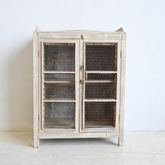 Vintage-style cabinet with wire mesh doors on a white background