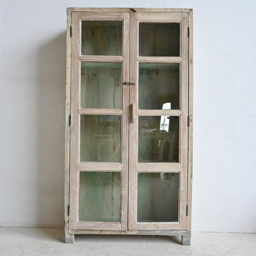 Vintage-style wooden cabinet with glass doors against a white wall