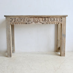 Wooden console table with intricate carvings on a white background