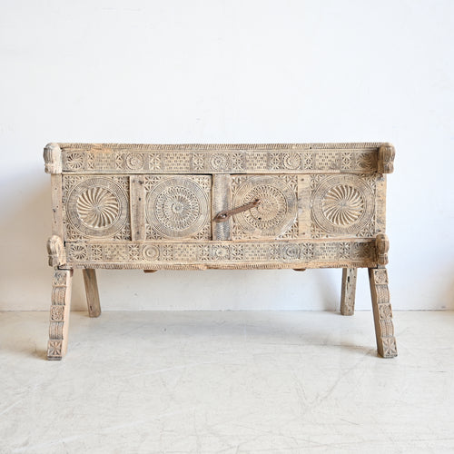 Wooden bench with intricate carvings on a white background