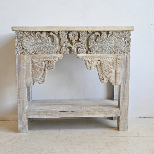 Carved wooden console table with intricate designs on a white background