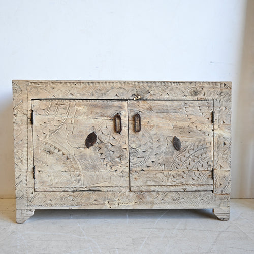 Carved wooden cabinet with intricate patterns on a white background