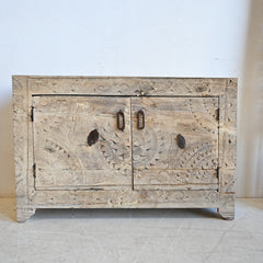 Wooden cabinet with intricate carvings on a white background