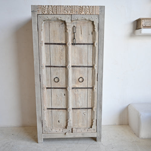 Vintage wooden wardrobe with intricate carvings on a white background