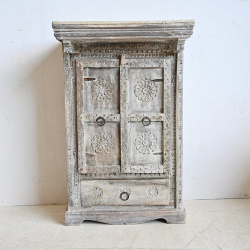 Vintage-style wooden cabinet with floral carvings on a white background