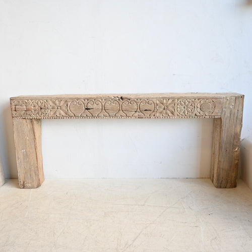 Carved wooden  Console/ mantel against a white wall