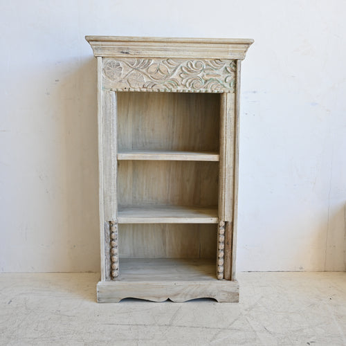Wooden bookshelf with intricate carvings on a white background