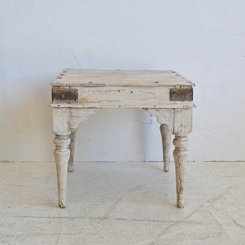 Vintage wooden side table with a distressed finish on a white background