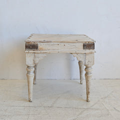 Vintage wooden side table with a distressed finish on a white background