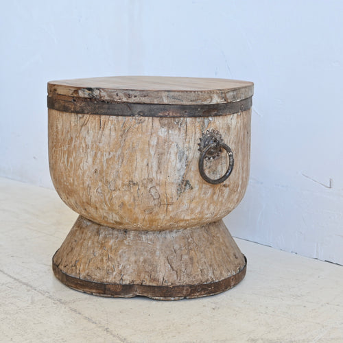 Wooden drum-style side table with metal accents on a white background